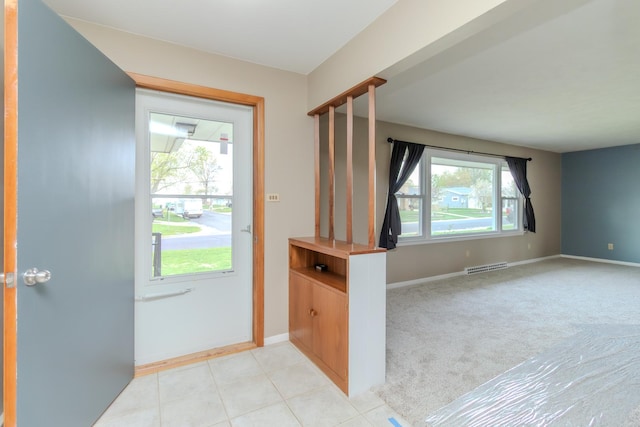 entrance foyer with baseboards and light carpet
