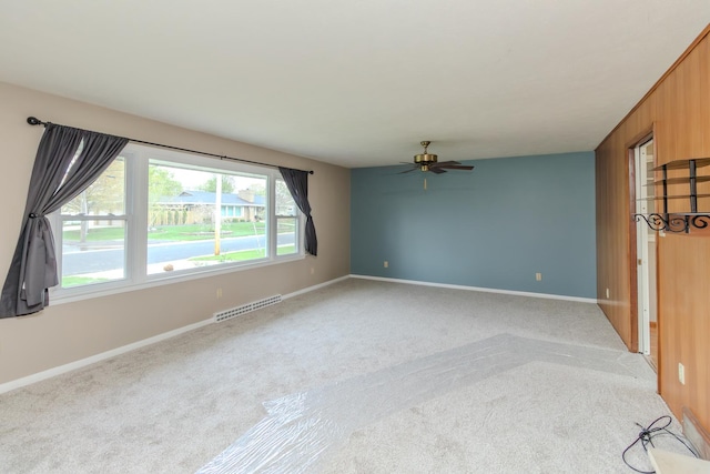 unfurnished room featuring light carpet, ceiling fan, and baseboards