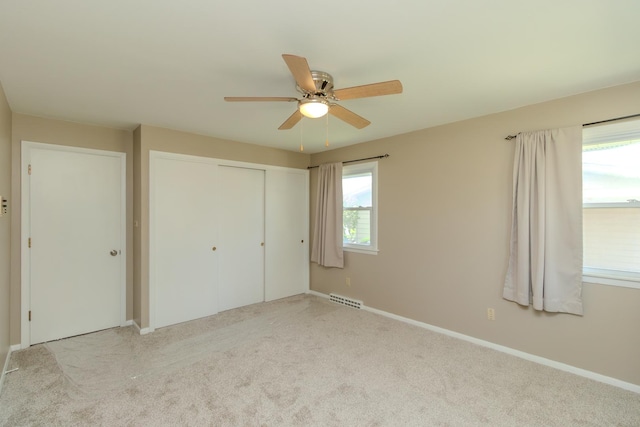 unfurnished bedroom with a closet, carpet, baseboards, and a ceiling fan