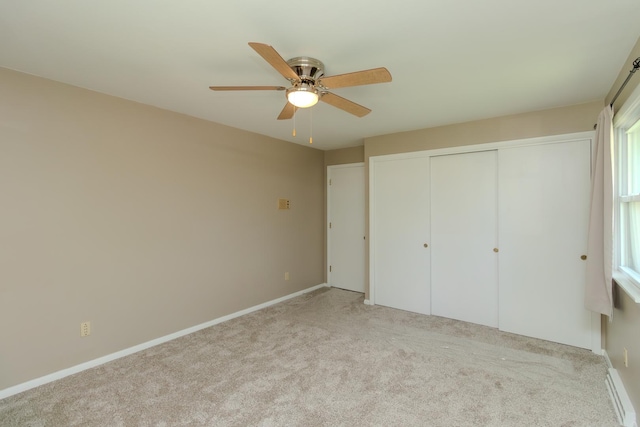 unfurnished bedroom with carpet, a closet, baseboards, and a ceiling fan