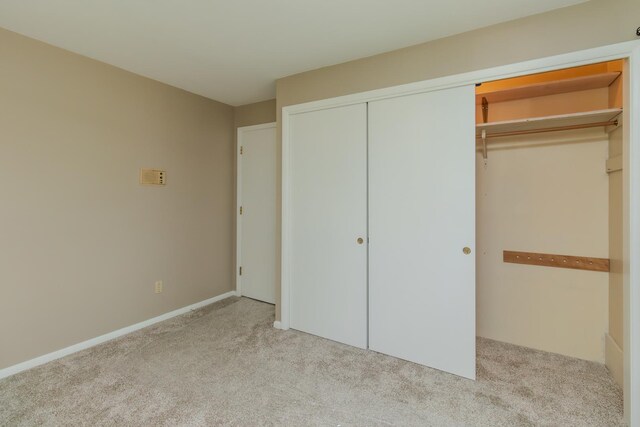 unfurnished bedroom with carpet and a closet