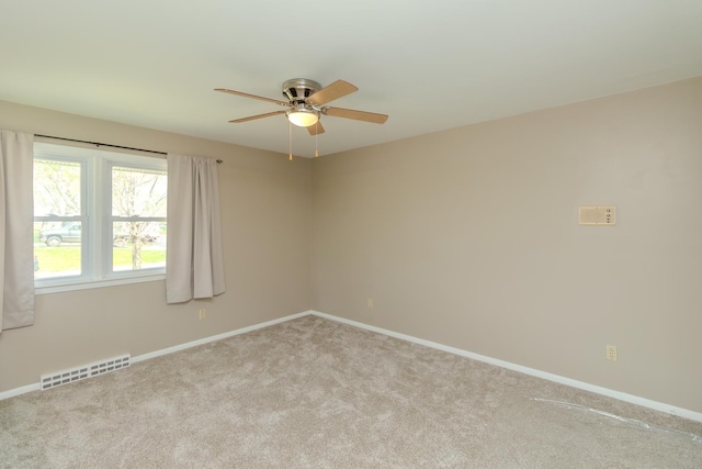 carpeted empty room featuring ceiling fan and baseboards