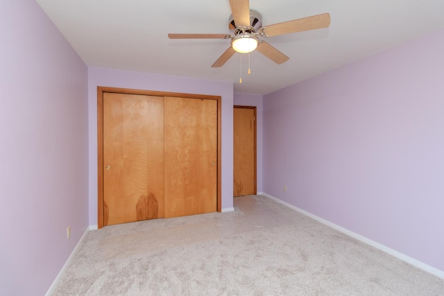 unfurnished bedroom featuring carpet floors, baseboards, ceiling fan, and a closet