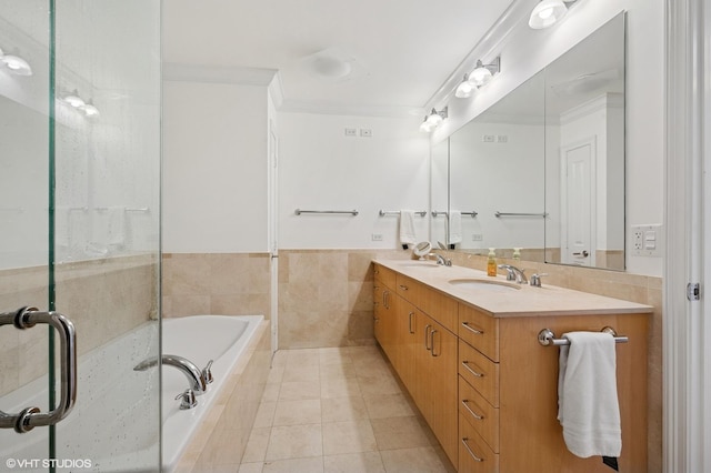 bathroom featuring a bath, ornamental molding, double vanity, and a sink