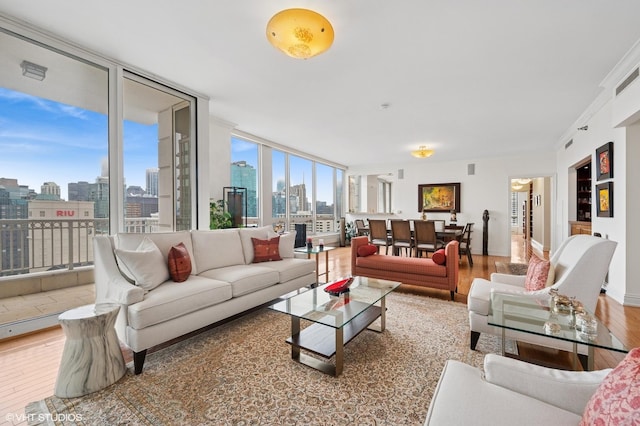 living room featuring floor to ceiling windows, a city view, baseboards, and wood finished floors