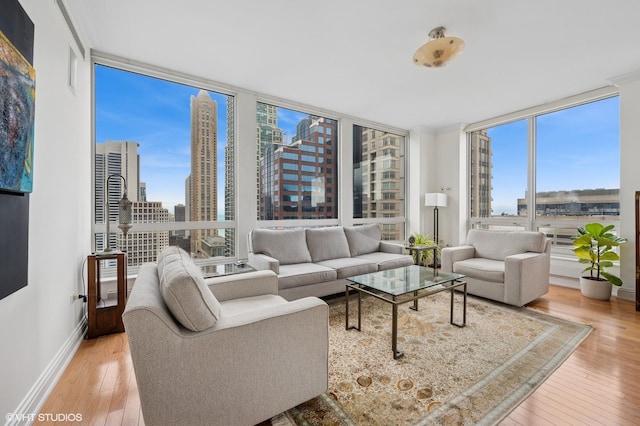 living room featuring expansive windows, hardwood / wood-style flooring, a city view, and a healthy amount of sunlight