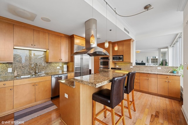 kitchen with a sink, stainless steel appliances, island exhaust hood, light wood-type flooring, and visible vents