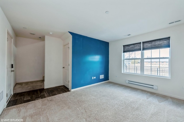 carpeted spare room with visible vents, baseboards, and baseboard heating