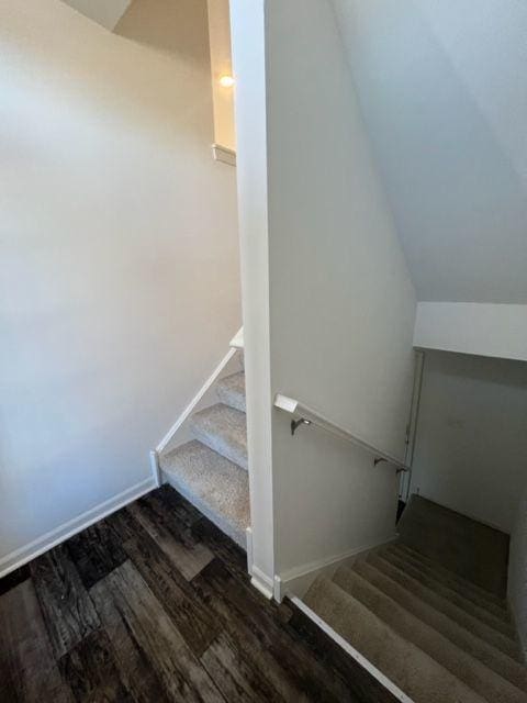 staircase featuring baseboards and wood finished floors