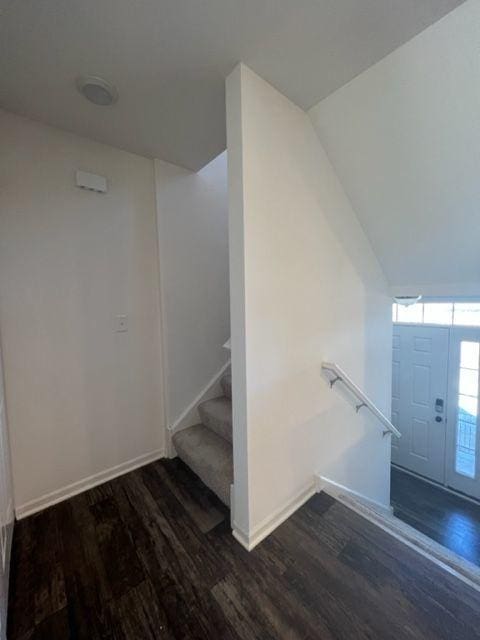 staircase featuring baseboards and wood finished floors