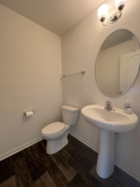 bathroom featuring toilet, baseboards, and wood finished floors