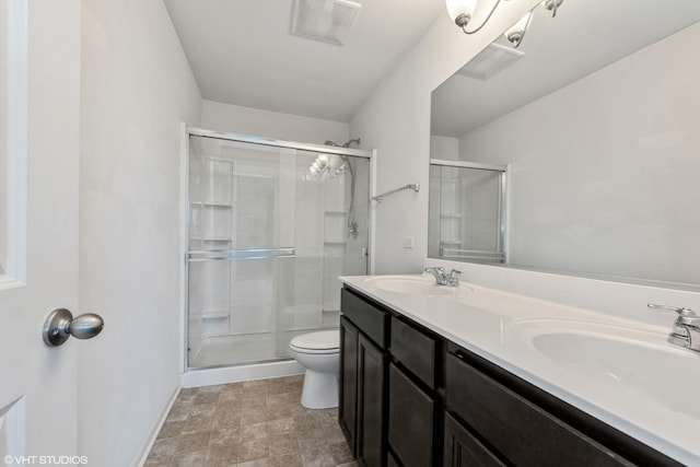 bathroom featuring toilet, a stall shower, and a sink