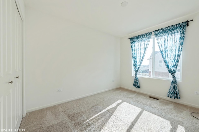carpeted empty room with baseboards and visible vents