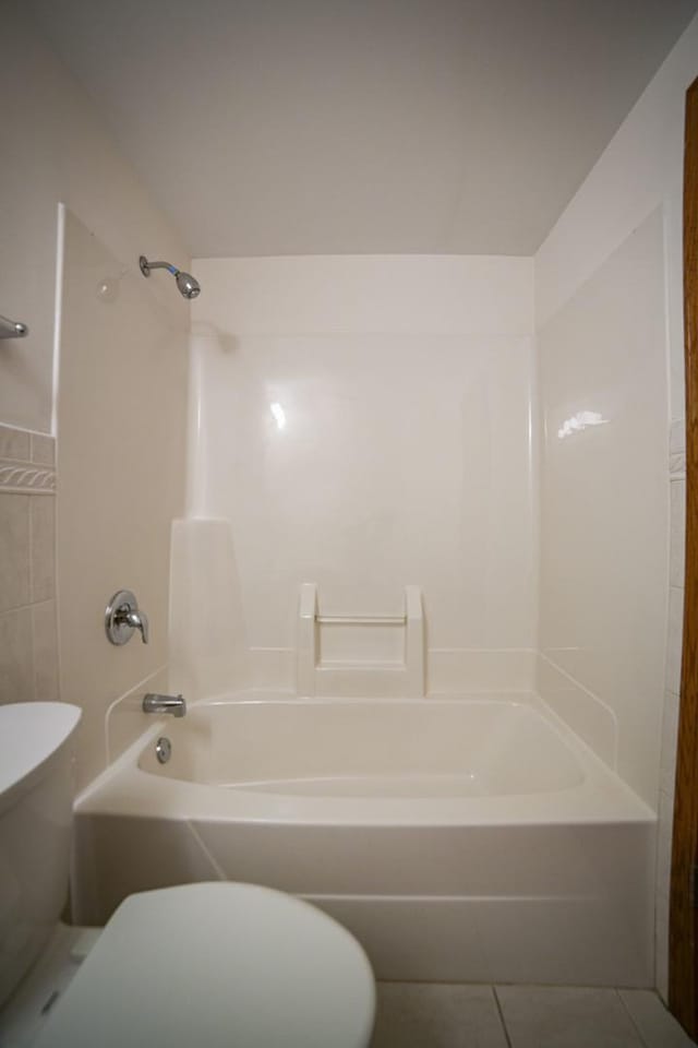 full bathroom featuring toilet, tile patterned floors, shower / bath combination, and tile walls