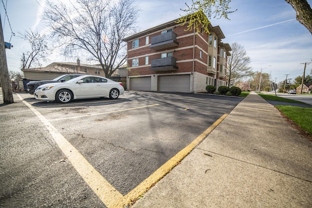 view of parking / parking lot with a garage and driveway