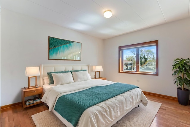 bedroom with baseboards and light wood finished floors