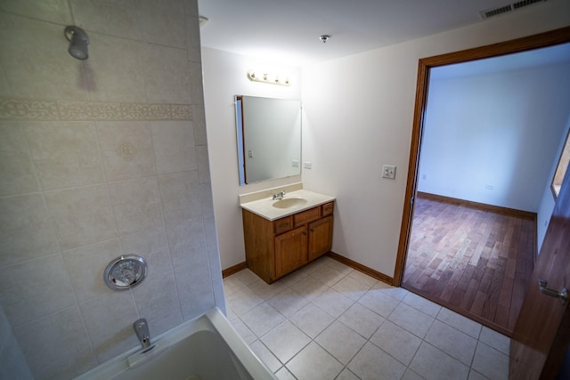 bathroom featuring vanity, tile patterned flooring, shower / washtub combination, and baseboards