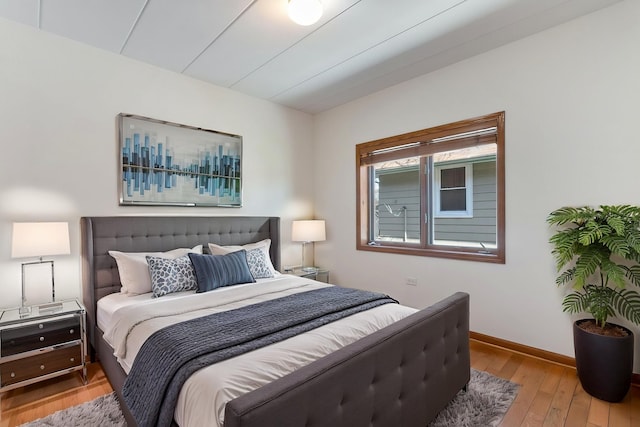 bedroom with wood-type flooring and baseboards