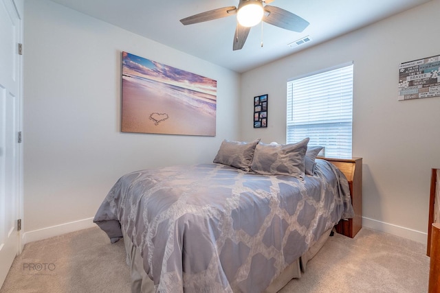 bedroom featuring light colored carpet, visible vents, baseboards, and a ceiling fan