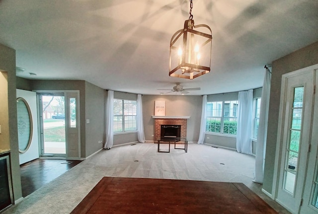 unfurnished living room featuring a fireplace, baseboards, carpet flooring, and ceiling fan