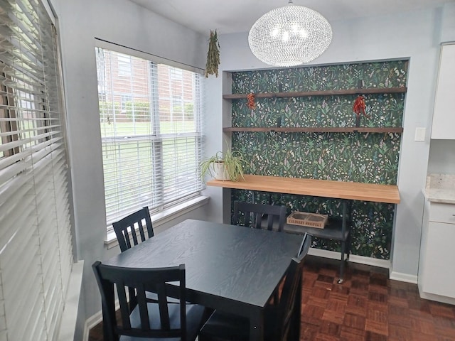dining room with a chandelier and baseboards