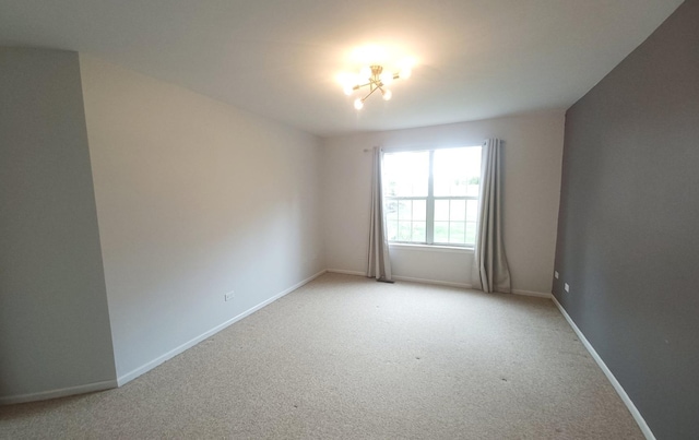 spare room with light carpet and baseboards