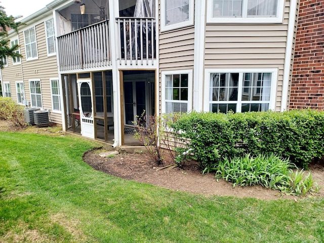 back of property featuring a lawn and cooling unit