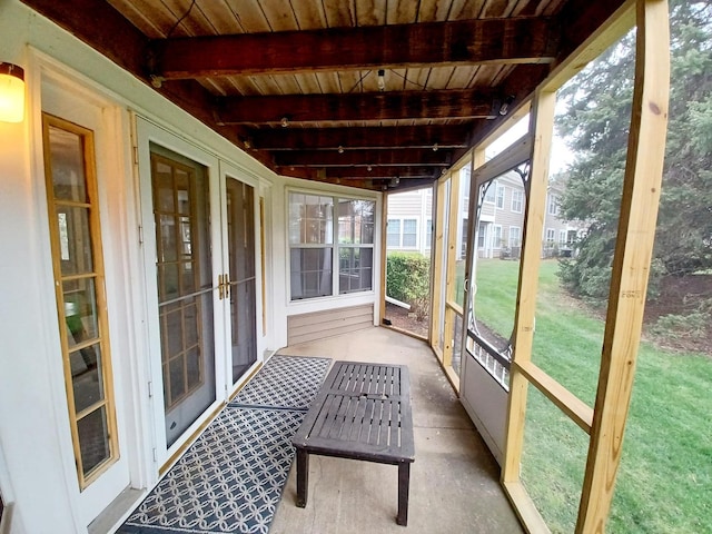 unfurnished sunroom with beam ceiling and french doors