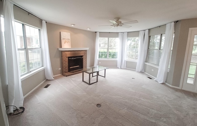 unfurnished living room with a ceiling fan, a fireplace, carpet floors, and baseboards