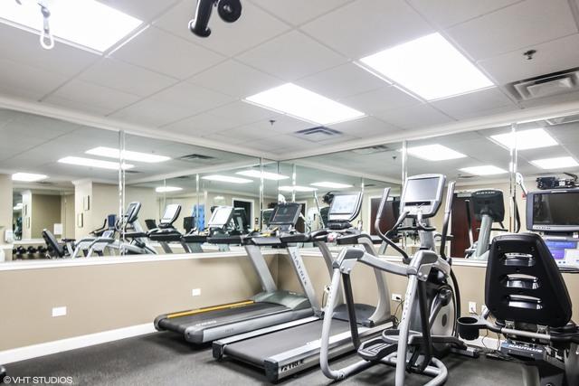 workout area with a paneled ceiling and baseboards