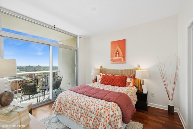 bedroom featuring access to outside, wood finished floors, baseboards, and expansive windows