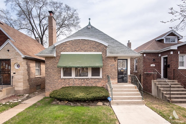 10041 S Calumet Ave, Chicago, IL 60628 - view of front of home featuring brick siding and a chimney