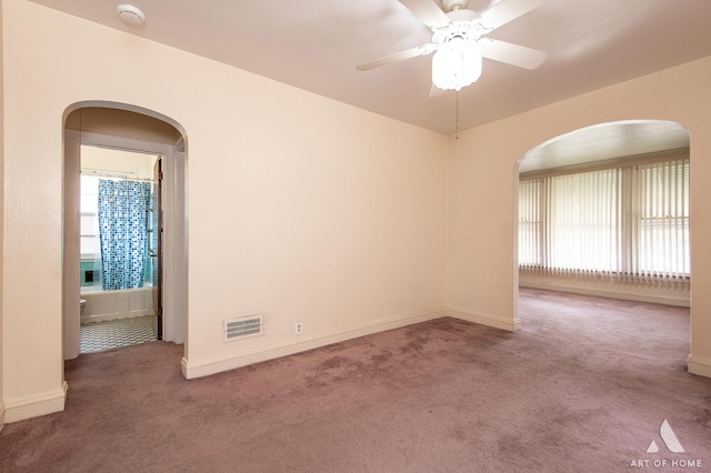 10041 S Calumet Ave, Chicago, IL 60628 - empty room featuring carpet, arched walkways, ceiling fan, baseboards, and a smoke detector
