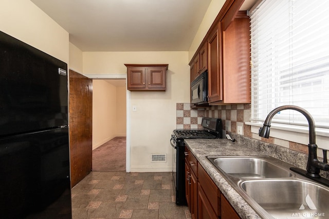 10041 S Calumet Ave, Chicago, IL 60628 - kitchen with black appliances, a sink, dark countertops, stone finish flooring, and baseboards