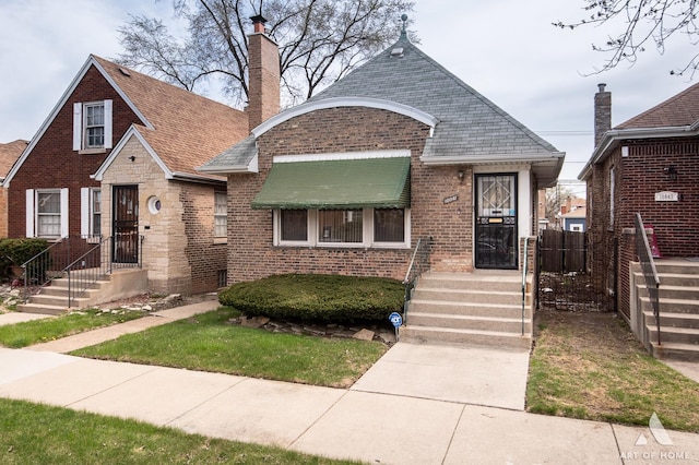 10041 S Calumet Ave, Chicago, IL 60628 - view of front of property with brick siding, a chimney, fence, and a shingled roof