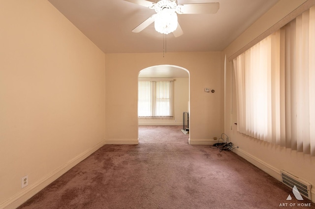 10041 S Calumet Ave, Chicago, IL 60628 - carpeted empty room featuring arched walkways, baseboards, and a ceiling fan