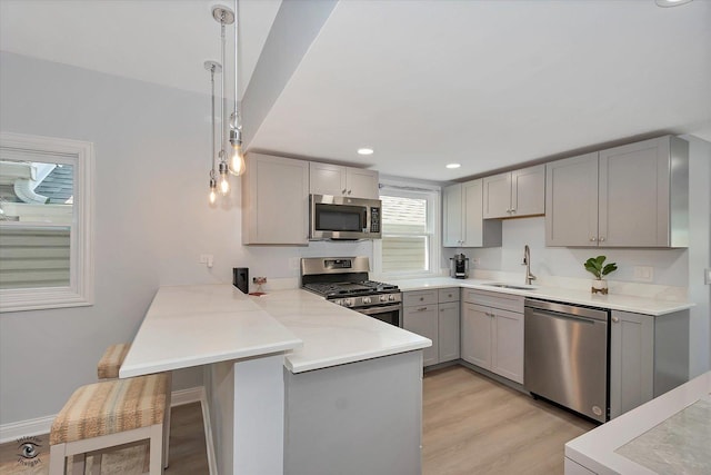 3530 S Union Ave, Chicago, IL 60609 - kitchen with a sink, a peninsula, stainless steel appliances, gray cabinets, and light wood finished floors