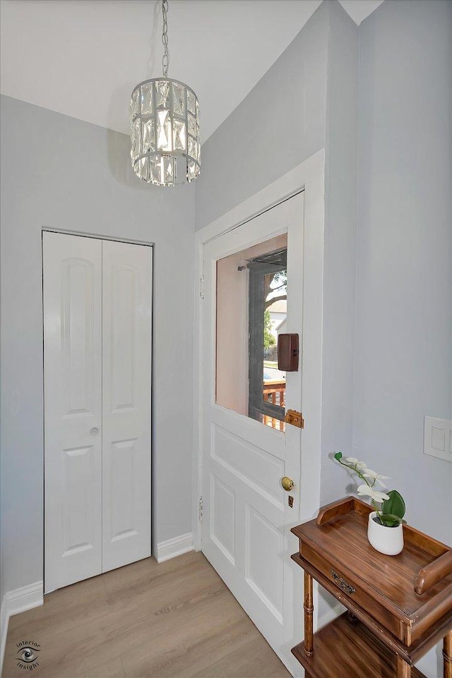 3530 S Union Ave, Chicago, IL 60609 - doorway to outside featuring baseboards, light wood-style floors, and an inviting chandelier