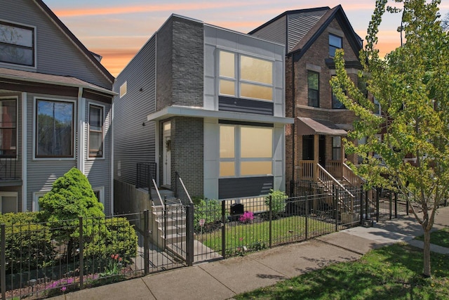view of front of house featuring a fenced front yard and brick siding