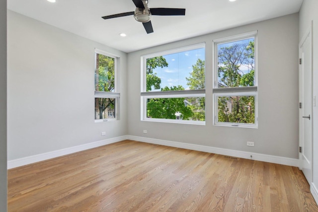 empty room featuring healthy amount of natural light, light wood-style flooring, baseboards, and recessed lighting