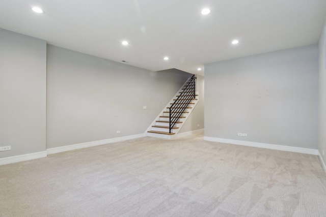 finished basement with recessed lighting, stairs, light carpet, and baseboards