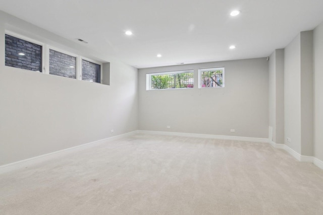 below grade area featuring recessed lighting, light carpet, and baseboards