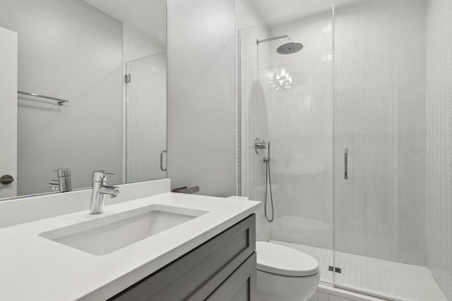 bathroom with toilet, a shower stall, and vanity