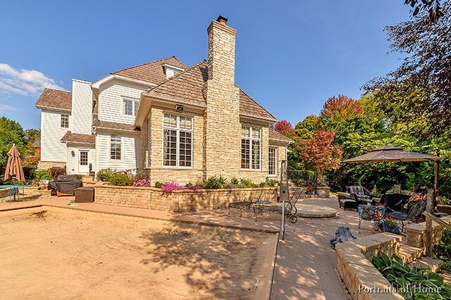 305 S Wright St, Naperville, IL 60540 - rear view of house featuring a chimney, a patio area, and stone siding