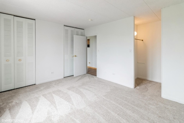 9701 N Dee Rd Unit 4C, Niles, IL 60714 - unfurnished bedroom featuring carpet, two closets, and baseboards