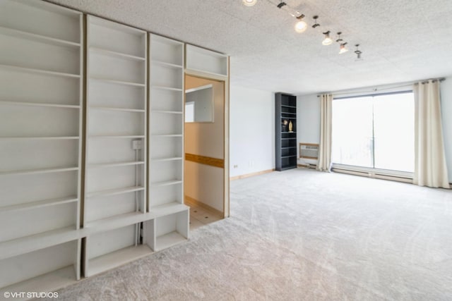 9701 N Dee Rd Unit 4C, Niles, IL 60714 - unfurnished living room with carpet, baseboards, a textured ceiling, a baseboard radiator, and rail lighting