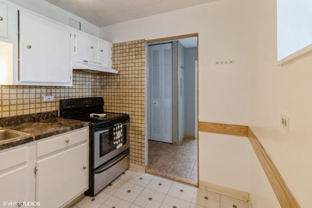9701 N Dee Rd Unit 4C, Niles, IL 60714 - kitchen with electric range oven, white cabinets, under cabinet range hood, dark countertops, and light tile patterned floors