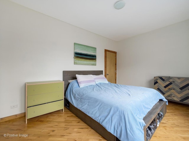 bedroom with wood finished floors and baseboards