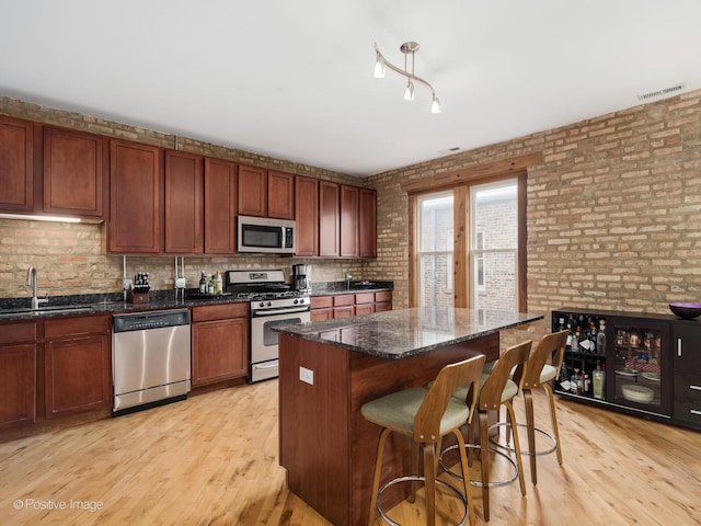 kitchen with a sink, light wood-style flooring, visible vents, and appliances with stainless steel finishes