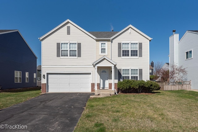 traditional-style home featuring an attached garage, asphalt driveway, a front lawn, and brick siding